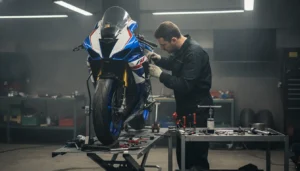 Préparateur moto réglant la suspension d'une moto sur pont d'atelier